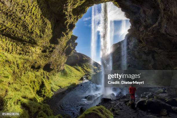 hiker at majestic kvernufoss waterfall in iceland - iceland landscape stock pictures, royalty-free photos & images