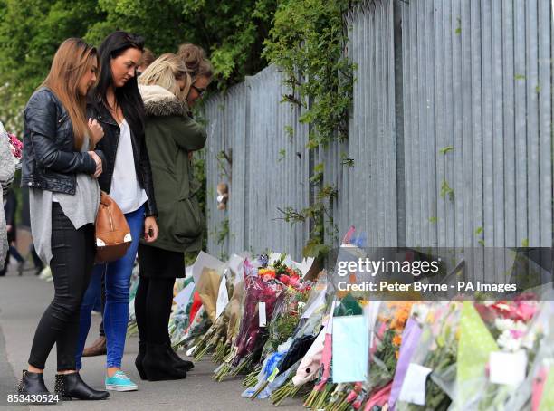 Flowers are left outside Corpus Christi Catholic College in Leeds, after much loved teacher Ann Maguire was stabbed to death yesterday in front of...