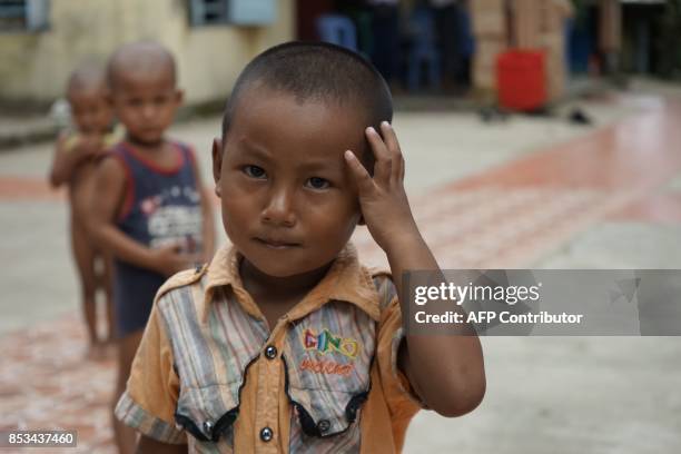 This photo taken on September 22, 2017 in Sittwe, Rakhine state, shows an ethnic Rakhine boy inside the compound of a monastery which is sheltering...