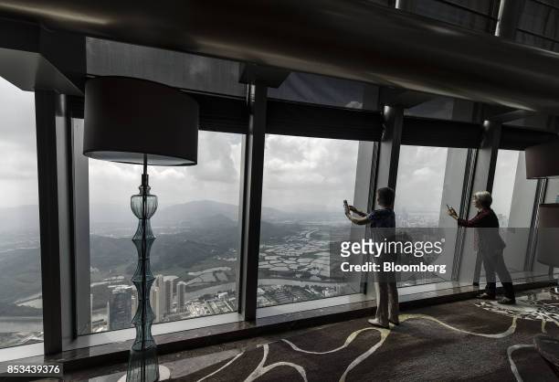 Visitors use their smartphones to take photographs from the observation deck of the KK100 tower in Shenzhen, China, on Wednesday, Sept. 20, 2017....