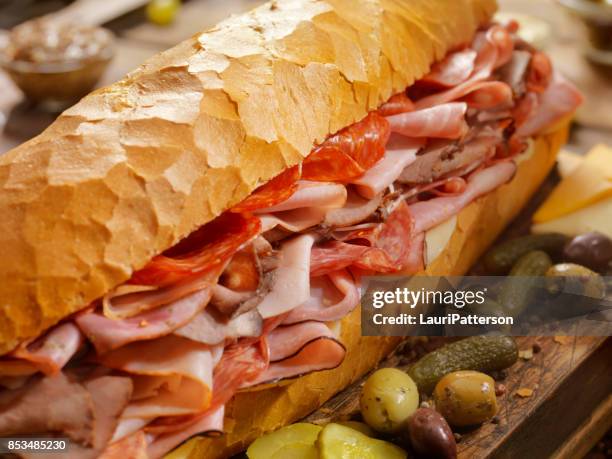 loaded party sub sandwich on a french loaf - ham salami stock pictures, royalty-free photos & images