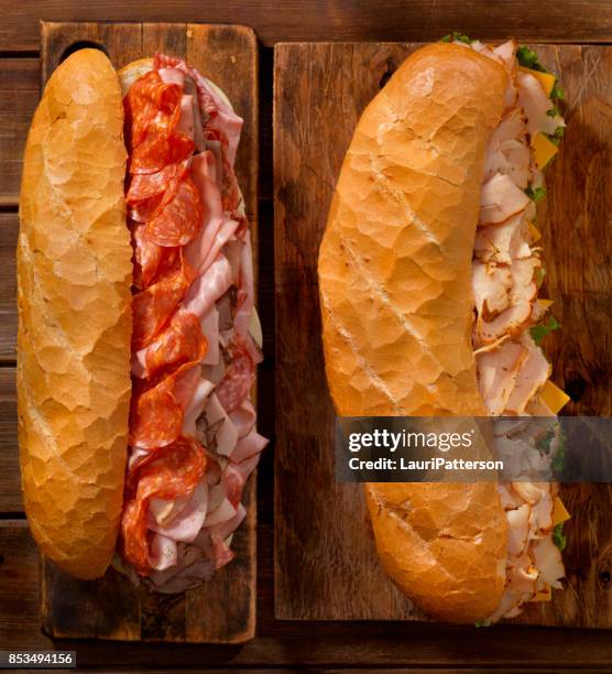 geladen partij sub sandwich op een frans brood - ham salami stockfoto's en -beelden