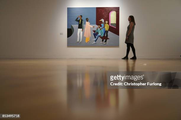 Member of staff poses for the media next to Le Rodeur: The Exchange 2016 by artist Lubaina Himid during a press preview for the 2017 Turner Prize at...