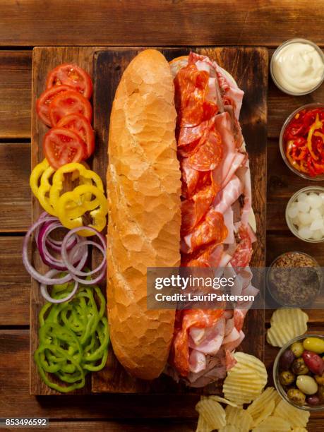 geladen partij sub sandwich op een frans brood - large cucumber stockfoto's en -beelden