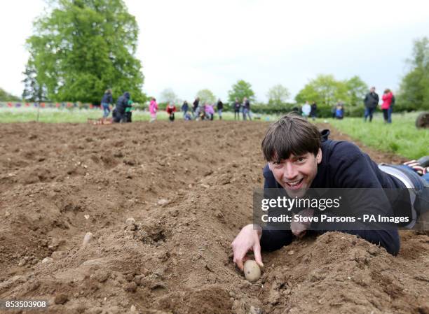 Alex James is helped planting potatoes by children from Kingham and Bledington Primary Schools at his farm near Kingham, Oxfordshire. The potatoes...