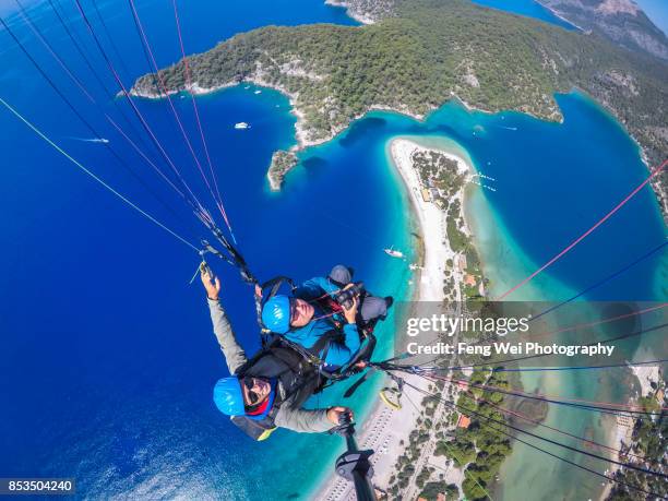 paragliding over mediterranean coast, oludeniz, fethiye, mugla, turkey - paragliding stock pictures, royalty-free photos & images