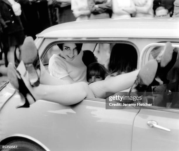 Photo of 60's STYLE; An attempt to get as many women as possible in to a mini car, legs sticking out of window