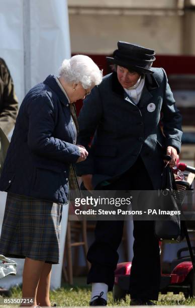 Queen Elizabeth II talks with Henrietta Knight she watches her horse Tower Bridge compete in the Cuddy 4 Year Old Hunter class on day one of the...