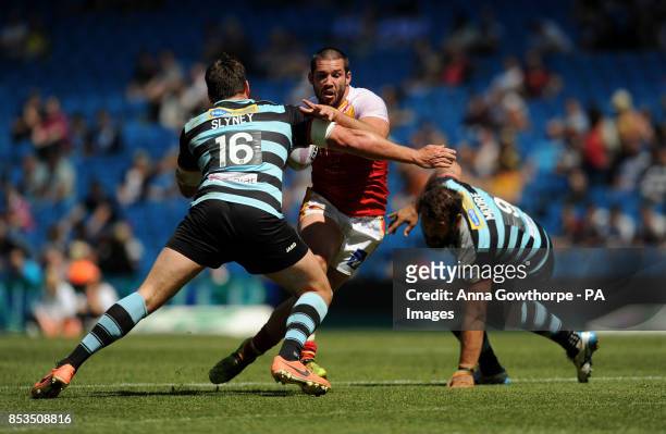 Catalan Dragons' Jason Baitieri runs at London Broncos' Nick Slyney and Scott Moore during the First Utility Super League Magic Weekend match at the...