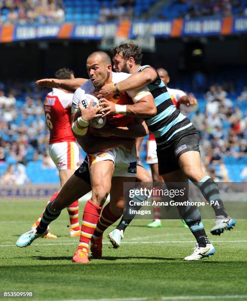 Catalan Dragons' Louis Anderson is tackled by London Broncos' Scott Moore during the First Utility Super League Magic Weekend match at the Etihad...