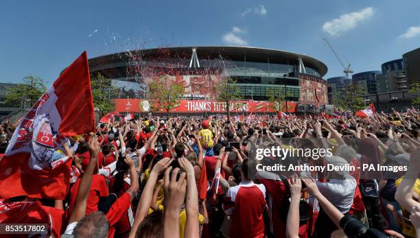 Arsenal players pose with the FA Cup outside the Emirates Stadium during the FA Cup winners parade in London.