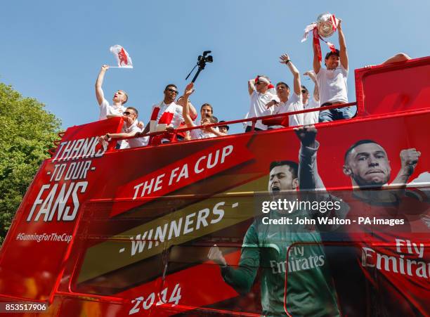 Aresenal's Santi Cazorla holds aloft the trophy during the FA Cup winners parade at Islington Town Hall, London.