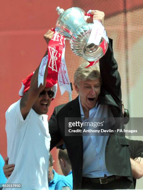 Arsenal's Theo Walcott and manager Arsene Wenger pose with the FA Cup outside the Emirates Stadium during the FA Cup winners parade in London.