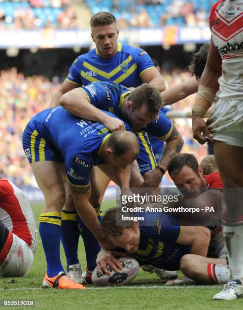 Warrington Wolves' Joel Monaghan is congratulated by teammates after scoring a try during the First Utility Super League Magic Weekend match at the...