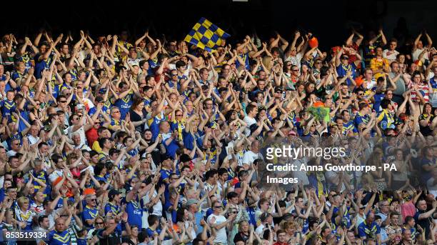 Warrington Wolves fans celebrate their team's victory during the First Utility Super League Magic Weekend match at the Etihad Stadium, Manchester.