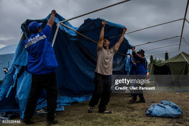 Volunteers build a temporary tent at evacuation center on September 25, 2017 in Klungkung regency, Island of Bali, Indonesia. Indonesian authorities...