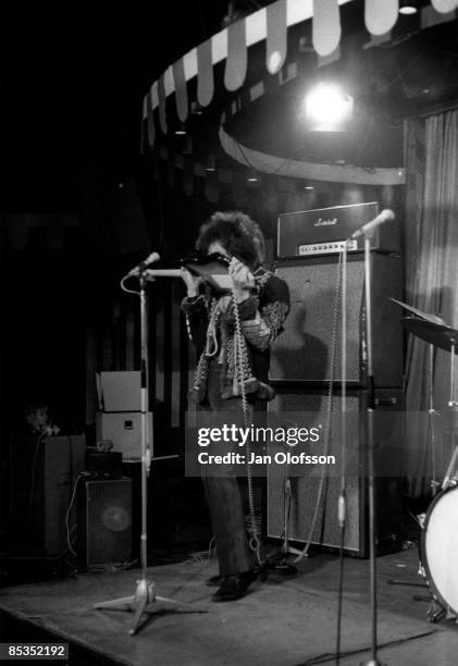 Photo of Jimi HENDRIX, Playing the guitar with his teeth live on stage