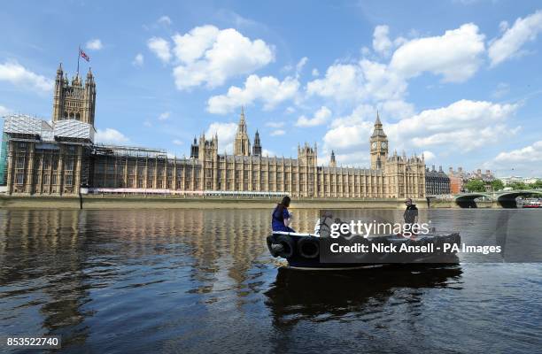 Members from the Sustainable Eel Group release 10,000 juvenile eels into the River Thames from a boat in front of the Houses of Parliament, central...