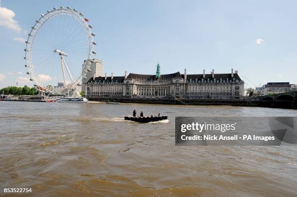 Members from the Sustainable Eel Group pass the London County Hall and the EDF Energy London Eye prior to releasing 10,000 juvenile eels into the...
