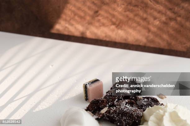 ice cream, whipped cream, lava cake, marzipan, sunflower seeds and coconut rasp. - lakritzmischung stock-fotos und bilder