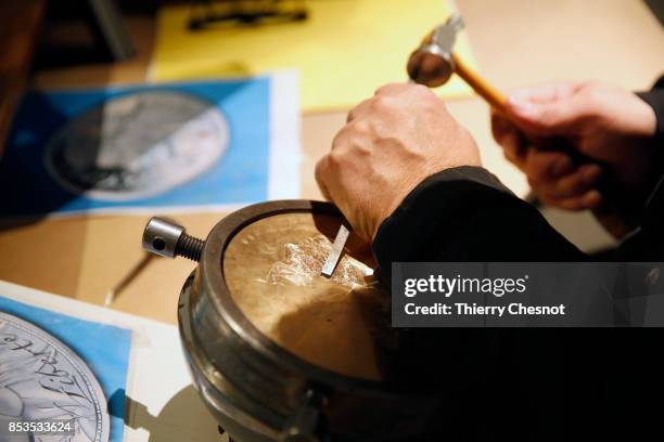 Craftman engraves a platinum used as a mold for a medal during the press visit at the "Monnaie de Paris" on September 25, 2017 in Paris, France....