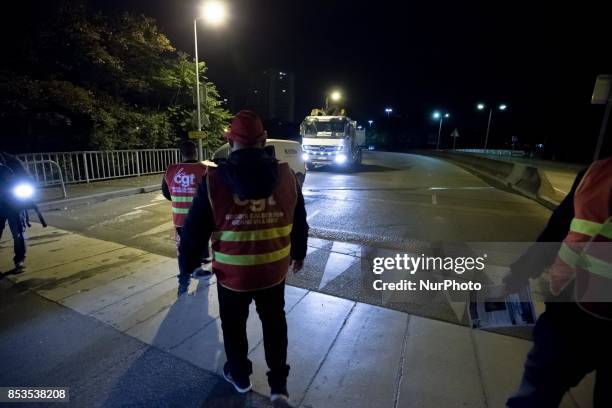 Lorry drivers from the French workers' union CGT block access roads to the Gennevilliers port, outside Paris, early on September 25 at the start of a...