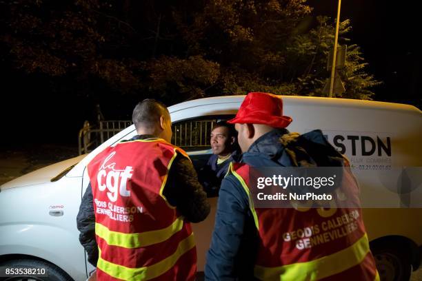 Lorry drivers from the French workers' union CGT block access roads to the Gennevilliers port, outside Paris, early on September 25 at the start of a...