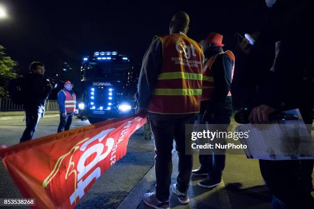 Lorry drivers from the French workers' union CGT block access roads to the Gennevilliers port, outside Paris, early on September 25 at the start of a...