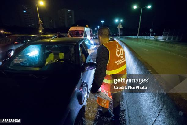 Lorry drivers from the French workers' union CGT block access roads to the Gennevilliers port, outside Paris, early on September 25 at the start of a...