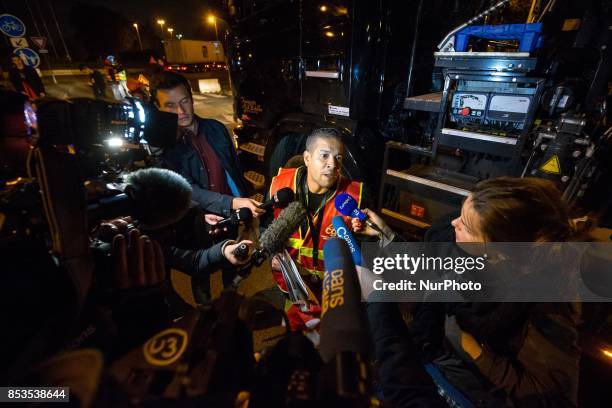 Lorry drivers from the French workers' union CGT block access roads to the Gennevilliers port, outside Paris, early on September 25 at the start of a...