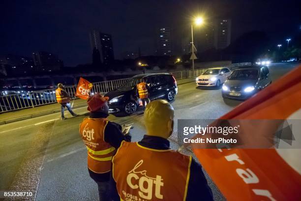 Lorry drivers from the French workers' union CGT block access roads to the Gennevilliers port, outside Paris, early on September 25 at the start of a...