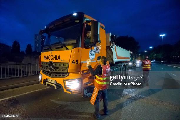 Lorry drivers from the French workers' union CGT block access roads to the Gennevilliers port, outside Paris, early on September 25 at the start of a...