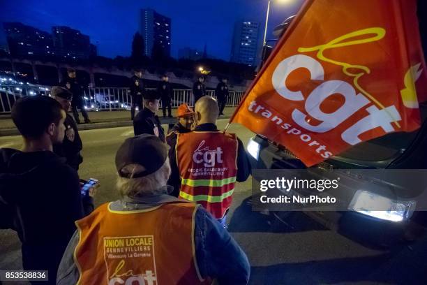 Lorry drivers from the French workers' union CGT block access roads to the Gennevilliers port, outside Paris, early on September 25 at the start of a...