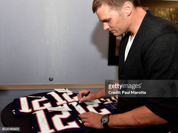 New England Patriots quarterback Tom Brady autographs football jerseys for the first purchasers of the Carrera Heuer 01 Limited Edition during the...