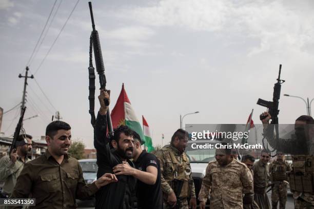 Peshmerga soldiers fire their guns in the air to celebrate the referendum on the road outside a voting station on September 25, 2017 in Kirkuk, Iraq....