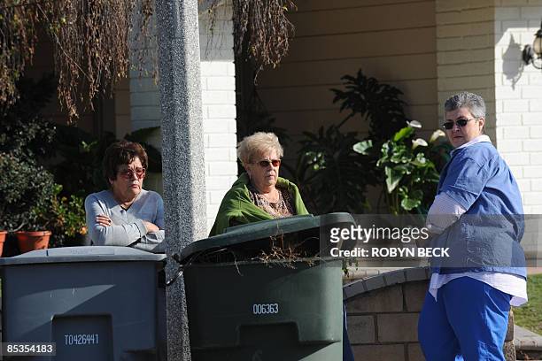 Neighbors watch as crowds of people gather outside the new house of Nadya Suleman, mother of octuplets born earlier this year, on March 10, 2009 in...