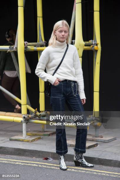 Model wears snakeskin boots, jeans and a white polo neck jumper on day 1 of London Womens Fashion Week Spring/Summer 2018, on September 15, 2017 in...