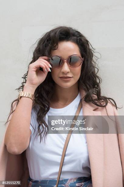 Fashion blogger Roxie Nafousi wears Moncler sunglasses, New Look jacket and a Never fully dressed top on day 1 of London Womens Fashion Week...