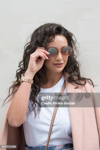 Fashion blogger Roxie Nafousi wears Moncler sunglasses, New Look jacket and a Never fully dressed top on day 1 of London Womens Fashion Week...