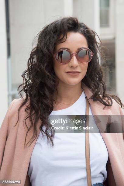 Fashion blogger Roxie Nafousi wears Moncler sunglasses, New Look jacket and a Never fully dressed top on day 1 of London Womens Fashion Week...