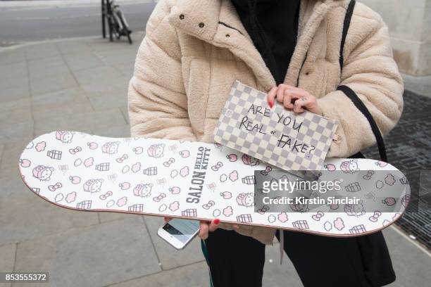 Model and skateboarder Stephani Nurding wears a Louis Vuitton bag, Urban Outfitters jacket and her own brand skateboard Salon on day 1 of London...