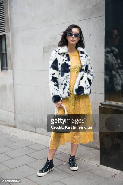Model and Actress Betty Bachz wears a Shrimps coat, bag and dress, converse trainers and Moy Atelier sunglasses on day 1 of London Womens Fashion...