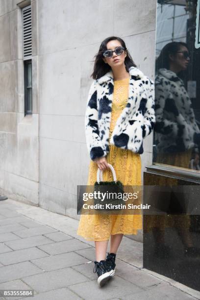 Model and Actress Betty Bachz wears a Shrimps coat, bag and dress, converse trainers and Moy Atelier sunglasses on day 1 of London Womens Fashion...