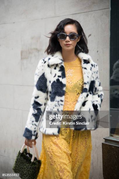 Model and Actress Betty Bachz wears a Shrimps coat, bag and dress and Moy Atelier sunglasses on day 1 of London Womens Fashion Week Spring/Summer...