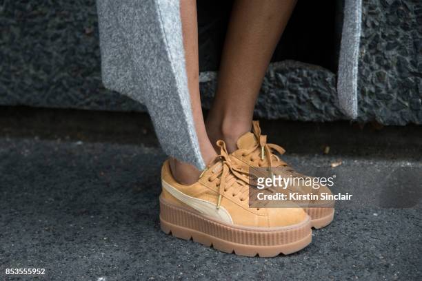 Fashion blogger Irene Iredia wears Fenty Puma trainers on day 1 of London Womens Fashion Week Spring/Summer 2018, on September 15, 2017 in London,...