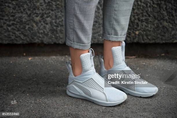 Fashion blogger Klaudia Wieteska wears Fenty Puma trainers and New Look trousers on day 1 of London Womens Fashion Week Spring/Summer 2018, on...