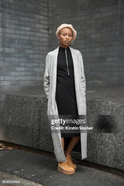 Fashion blogger Irene Iredia wears Fenty Puma trainers, Miss guided dress and jacket, Urban Outfitters hat and earrings on day 1 of London Womens...