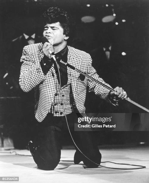 Photo of James BROWN; James Brown performing on stage, on knees