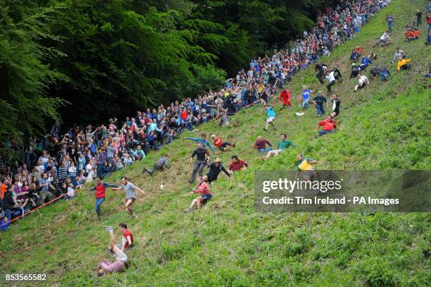 Competitors in the Cheese Rolling on Cooper's Hill race near Brockworth, Gloucestershire. PRESS ASSOCIATION Photo. Picture date: Monday May 26, 2014....