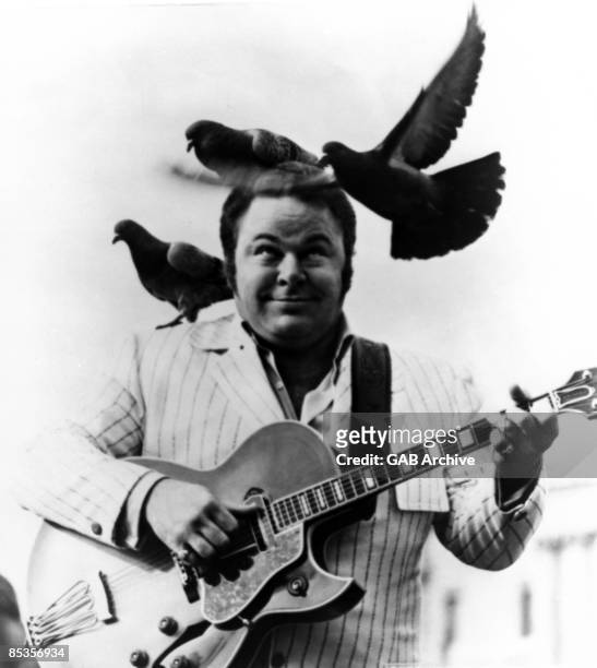 Photo of Roy CLARK; Performing with birds on his head